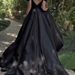 Rückansicht eines modernen schwarzen Satin-Brautkleids mit tiefer V-Rückenpartie und langer Schleppe