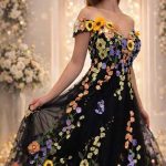 Nahaufnahme eines schwarzen Brautkleids mit bunten 3D-Blumenstickereien am Carmen-Ausschnitt